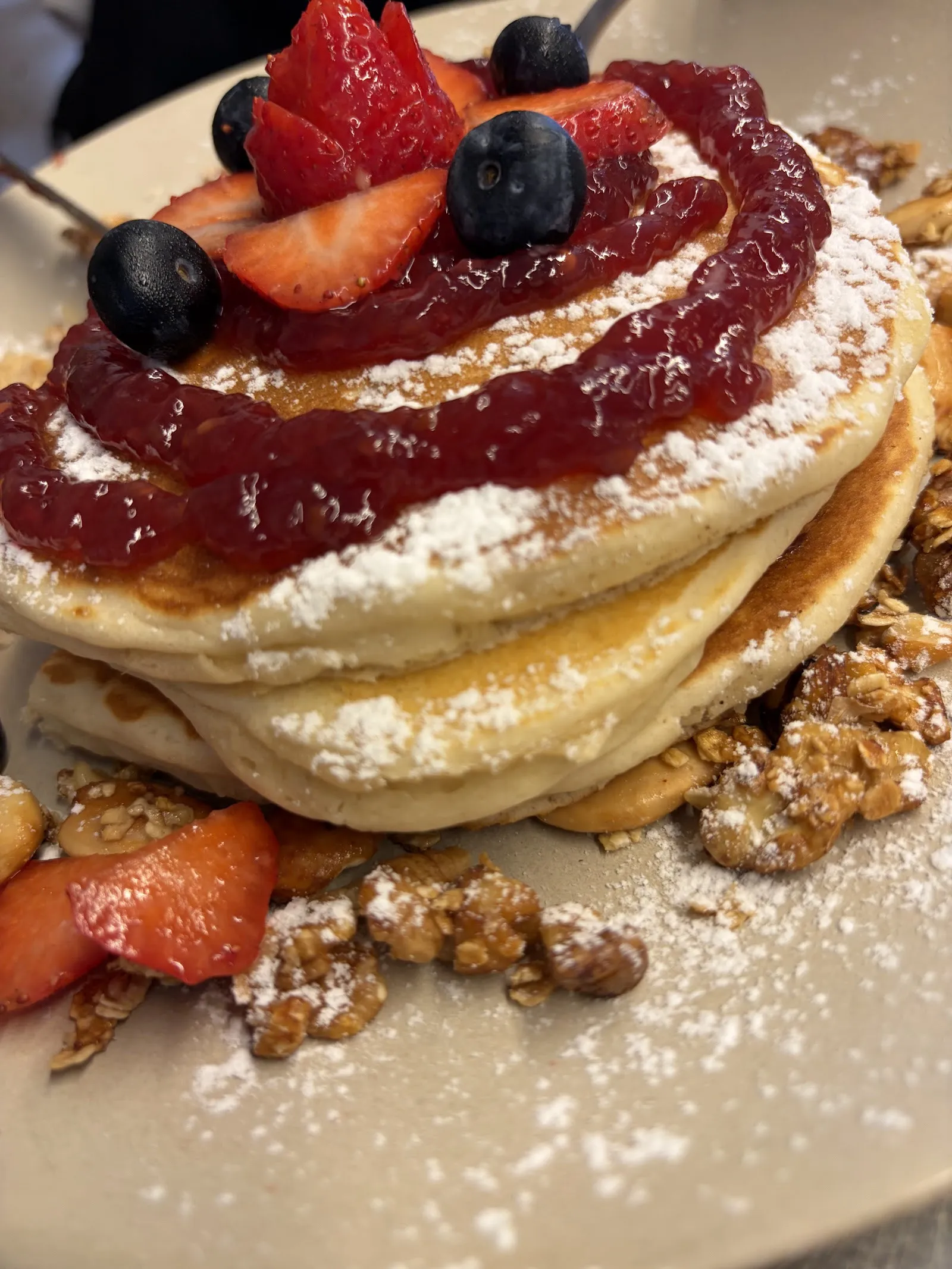 Pancakes con confitura roja, fresas, arándanos y nueces